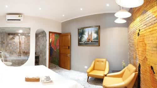 a bedroom with a bed and a yellow chair at Saigon1984 Vintage Private Home Central District 1 with 6 bedrooms and 6 bathrooms in Ho Chi Minh City