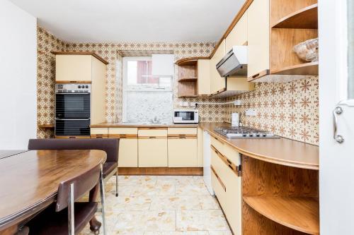 a kitchen with wooden cabinets and a wooden table at Russell Square Hotel in London