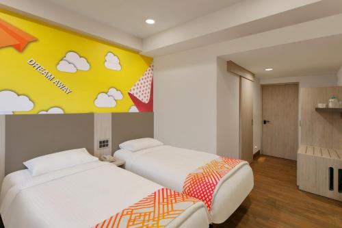 a bedroom with two beds and a wall with clouds at Ginger Patna in Patna