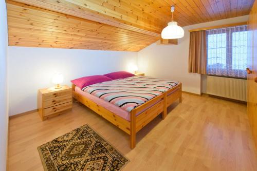 um quarto com uma cama grande e um tecto de madeira em Schmiedstube 420 em Grächen