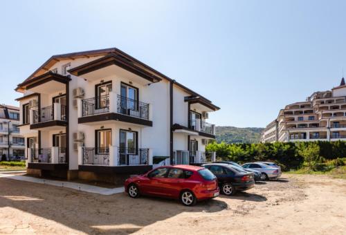 un coche rojo estacionado frente a un edificio en Guest House Theona, en Obzor