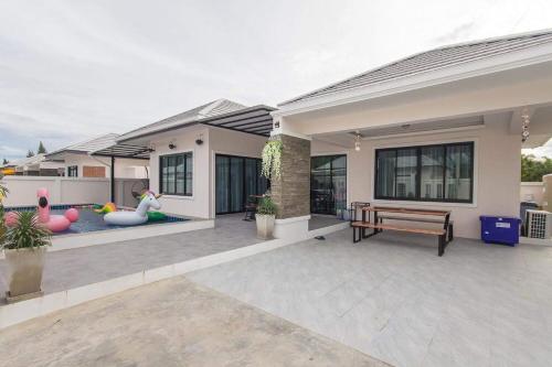 uma casa com um banco à frente em Thanycia Pool Villa em Hua Hin