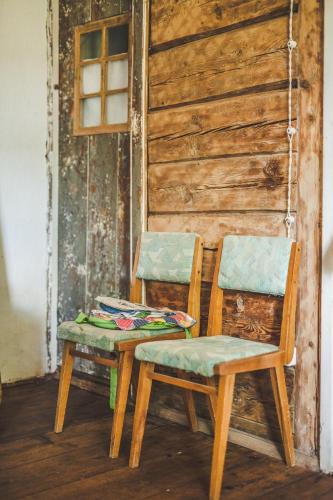 two chairs and a table in a room at Pagulbis - Tavo namai in Klabiniai