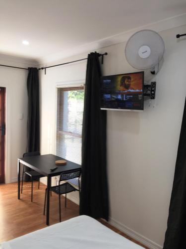 a room with a table and a tv on a wall at Gold Coast way Brisbane in Ormeau
