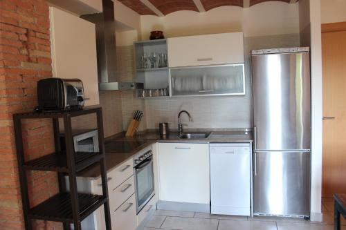 a kitchen with a stainless steel refrigerator and cabinets at Duplex para 4 en Cercs, Berga- A 30 mins del Pedraforca in Sant Corneli de Cercs 