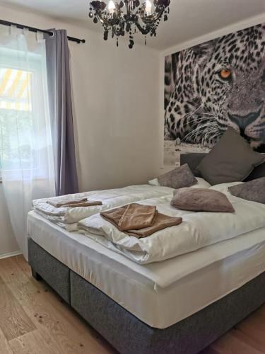 a large bed in a bedroom with a chandelier at Enjoyit Velden West in Selpritsch