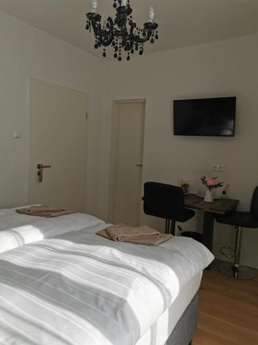 a bedroom with a bed and a desk and a chandelier at Enjoyit Velden West in Selpritsch