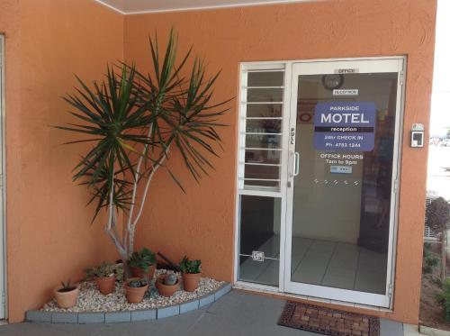 a front door of a motel with potted plants outside at Parkside Motel Ayr in Ayr