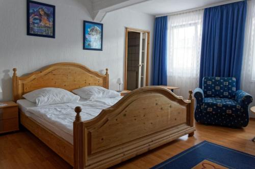 a bedroom with a wooden bed and a chair at Pension Burger B&B in Weibersbrunn