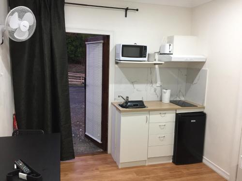 a small kitchen with a counter and a microwave at Gold Coast way Brisbane in Ormeau