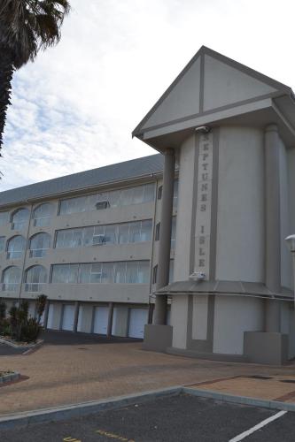 a large white building with a clock on it at Lagoon Beach Neptune Isle Cape Town in Cape Town