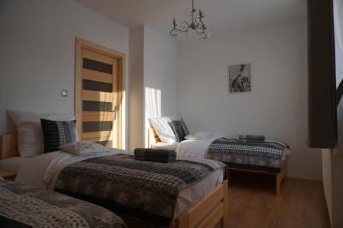 een slaapkamer met 2 bedden en een kroonluchter bij Domek u Matusa in Biały Dunajec