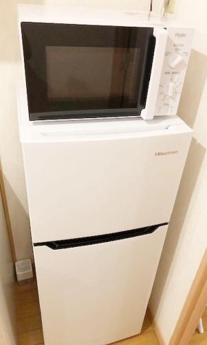 a microwave sitting on top of a white dresser at ピオーレ大手門401 in Fukuoka
