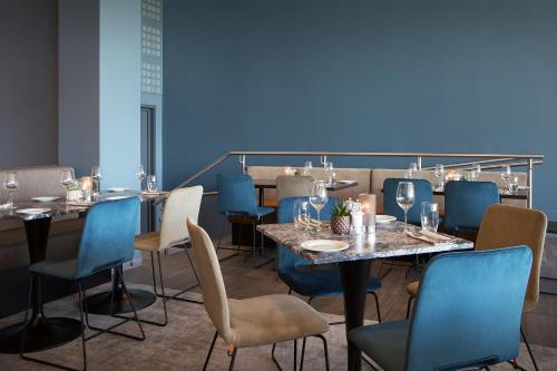 a dining room with tables and chairs and blue walls at Park Inn by Radisson Oslo Airport Hotel West in Gardermoen