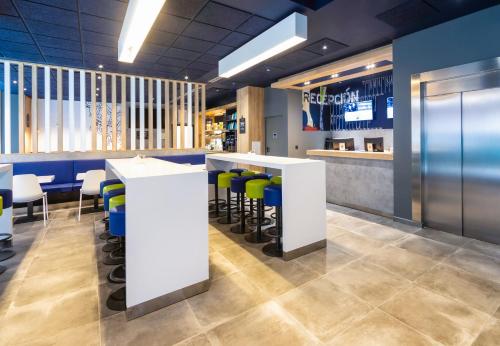a restaurant with a bar with stools at Ibis Budget Bilbao City in Bilbao