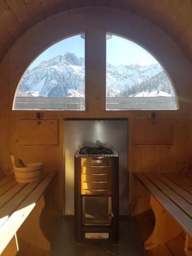 a small room with two windows and a stove at Residence Club Ponte Di Legno in Ponte di Legno