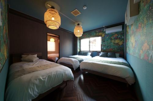 three beds in a room with blue walls at Airstar Fukuoka Airport x Sakono building in Fukuoka