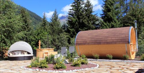 a wooden building with a fireplace in a garden at Residence Club Ponte Di Legno in Ponte di Legno