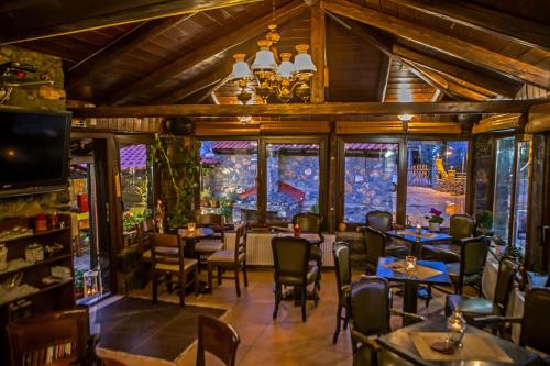 a restaurant with tables and chairs and windows at METOHI INN in Palaios Agios Athanasios