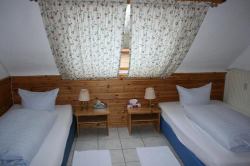 two beds in a room with two tables and two lamps at Hotel Restaurant Anna in Ramstein-Miesenbach