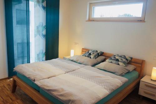 a bedroom with a large bed with a window at Hengnau 46, Ferienwohnung Stiefel in Wasserburg am Bodensee