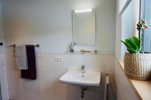 a white bathroom with a sink and a mirror at Hengnau 46, Ferienwohnung Stiefel in Wasserburg am Bodensee