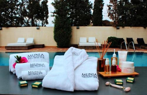 a table with towels and candles next to a swimming pool at Lamunia Hotel in Trâblous