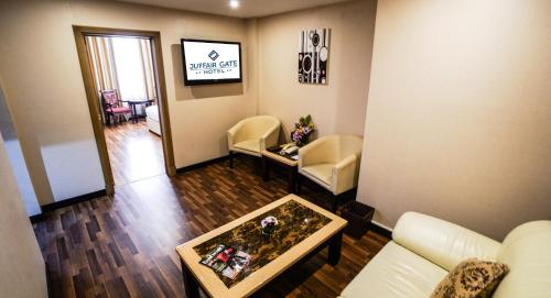 sala de estar con sofá y mesa en Juffair Gate Hotel, en Manama