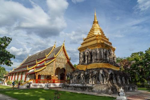 a large building with a pagoda in front of it at Darley Hotel Chiangmai in Chiang Mai