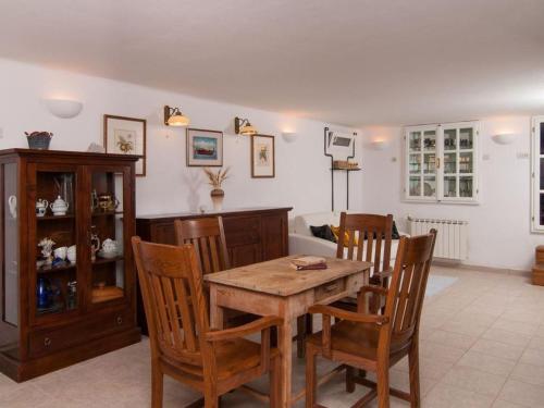 a dining room with a wooden table and chairs at Deluxe Villa Sirena on the beach with Pool in Supetar