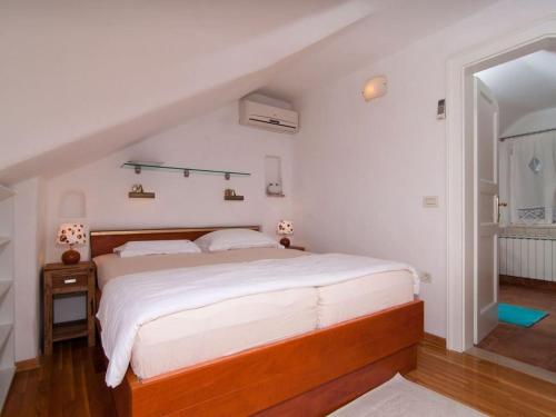 a bedroom with a large bed with white sheets at Deluxe Villa Sirena on the beach with Pool in Supetar