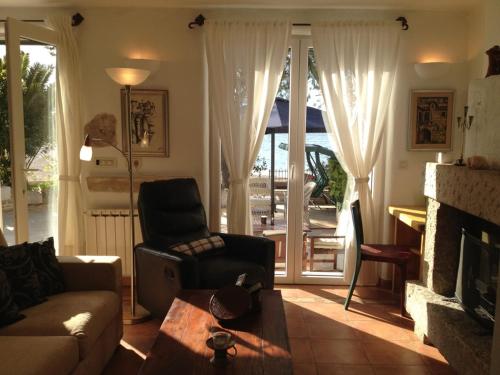 a living room with a couch and a chair and a fireplace at Deluxe Villa Sirena on the beach with Pool in Supetar
