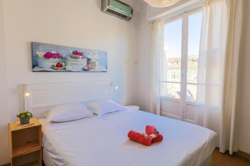 ein Schlafzimmer mit einem Bett mit einem roten Teddybär darauf in der Unterkunft Palais l'Escurial AP4069 by Riviera Holiday Homes in Nizza