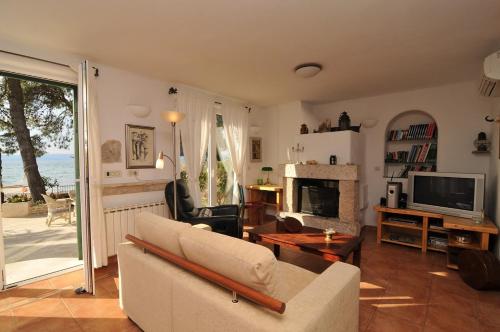 a living room with a couch and a fireplace at Deluxe Villa Sirena on the beach with Pool in Supetar