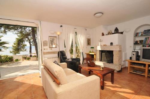 a living room with a couch and a fireplace at Deluxe Villa Sirena on the beach with Pool in Supetar