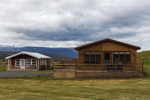 un par de edificios en un campo con montañas en Guesthouse Brekka, en Brekka