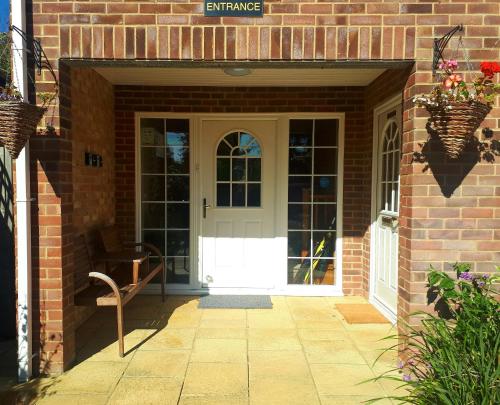 an entrance to a brick house with a white door at Berry House Bed & Breakfast in Littlehampton