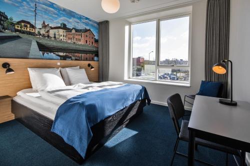 a hotel room with a bed and a desk at KOMPAS Hotel Aalborg in Aalborg