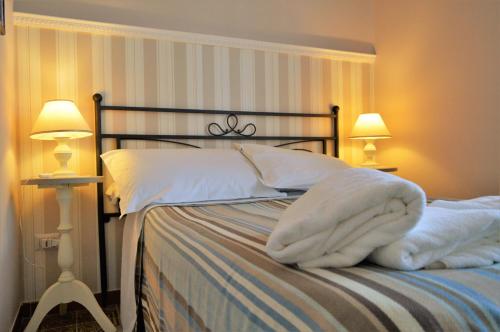 1 dormitorio con 1 cama con sábanas blancas y 2 lámparas en B&B Al Golfo, en Salerno