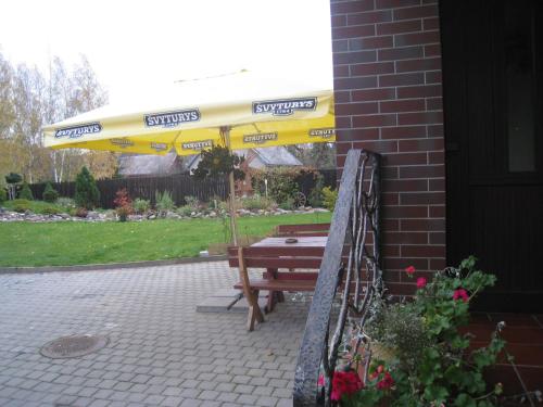 a yellow umbrella sitting next to a picnic table at Aroma Skuodiškio Užeiga in Skuodas