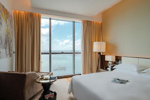 a hotel room with a bed and a large window at Johari Rotana in Dar es Salaam