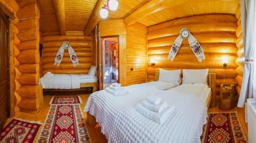 a bedroom with a bed in a log cabin at Casutele Din Moisei in Moisei
