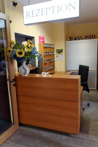 a reception desk with a vase of flowers on it at PrivatHotel Probst in Nürnberg
