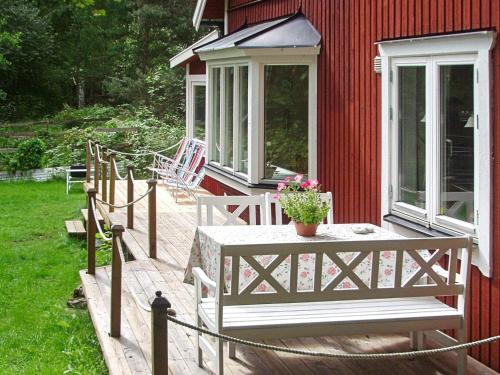 a wooden deck with a table and flowers on a house at 4 star holiday home in SOLLENTUNA in Sollentuna