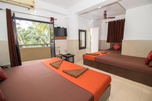 a hotel room with two beds and a window at Travo Suites Panjim in Panaji