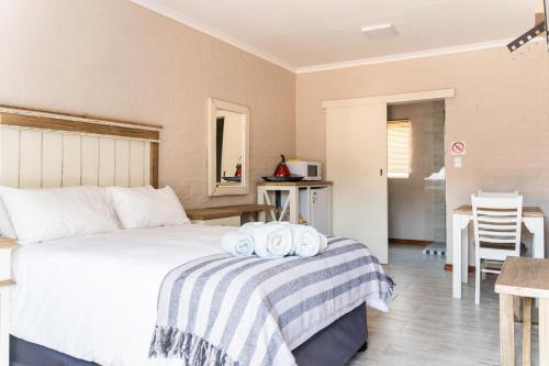 a bedroom with a bed with two towels on it at Opstal Guestfarm in Potchefstroom
