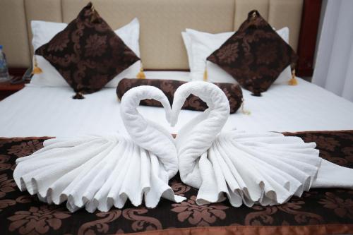 two swans made out of towels on a bed at Khujand Deluxe Hotel in Khujand