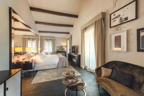 a hotel room with a bed and a couch at DOM Hotel Roma - Preferred Hotels & Resorts in Rome