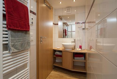 ein Bad mit einem Waschbecken und einem Spiegel in der Unterkunft Weißenbach´s Ferienhof in Wertach