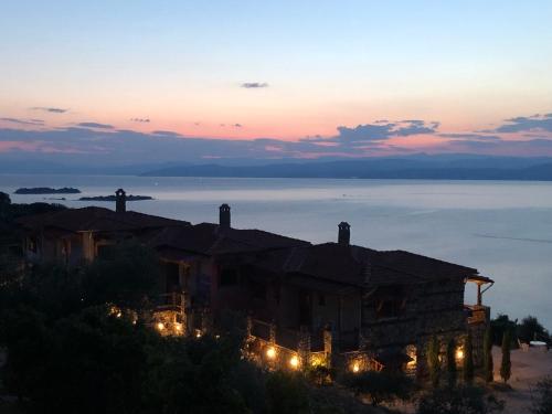 a house with lights in front of the ocean at sunset at Ammou Area in Ammouliani